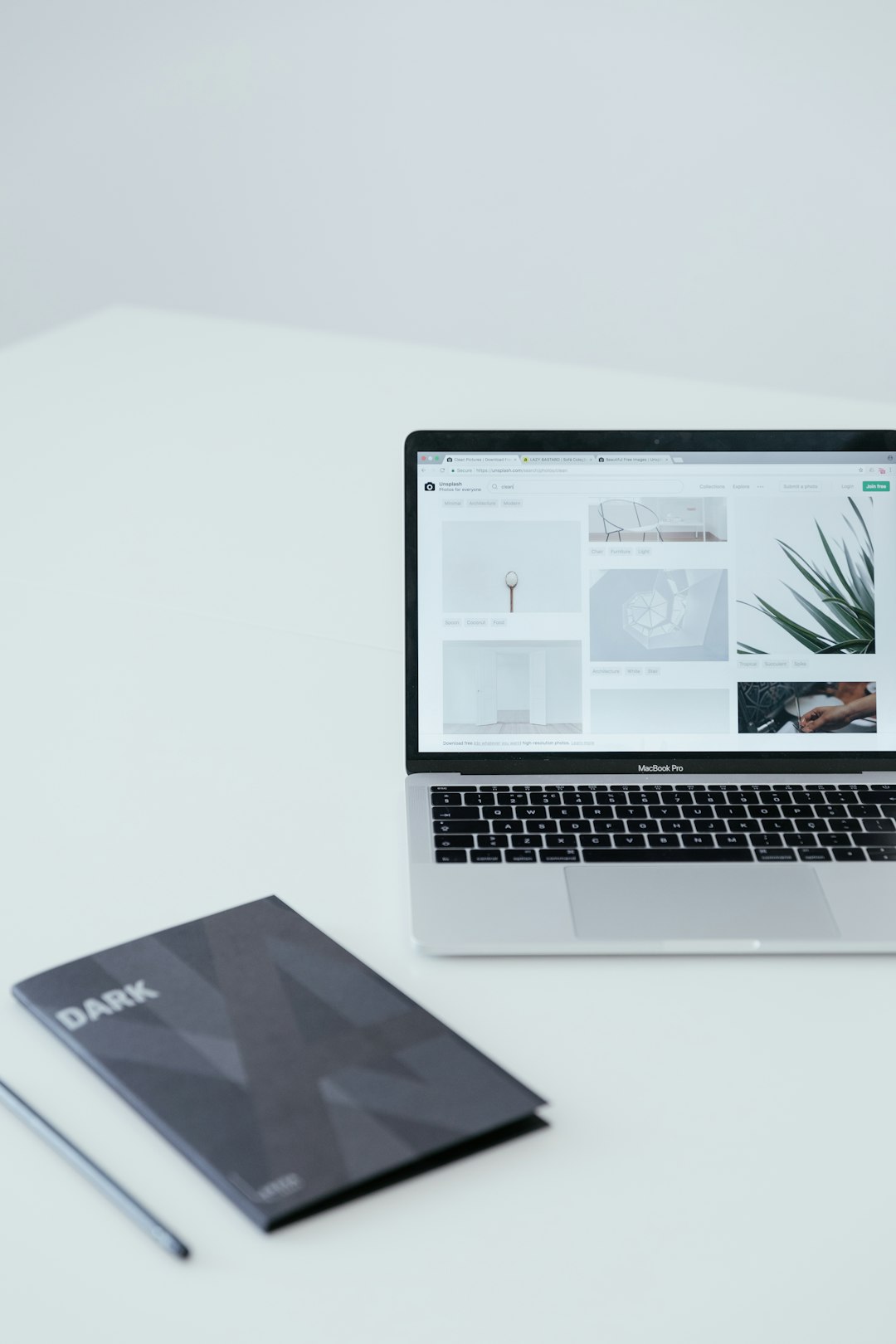 White minimal setup with Macbook Pro and notebook